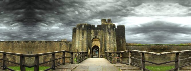 Trip Ferienwohnung Reisetipps - Caerphilly Castle - ein Bollwerk aus dem 13. Jahrhundert in Wales, Vereinigtes Königreich. Mit einem aufsehenerregenden Turm, der schiefer ist wie der Schiefe Turm zu Pisa. Wie jede Burg mit Prestige, hat sie auch einen Geist, „The Green Lady“ spukt in den Gemächern, wo ihr Geliebter den Tod fand. Wo man in Wales oft – und nicht ohne Grund – das Gefühl hat, dass ein Schloss ziemlich gleich ist, ist Caerphilly Castle bei Cardiff eine sehr willkommene Abwechslung. Die Burg ist nicht nur deutlich größer, sondern auch älter als die Burgen, die später von Edward I. als Ring um Snowdonia gebaut wurden.